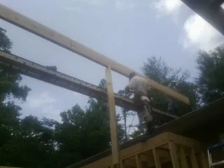 Carpenter setting a ridge beam over a new addition frame — Ice Dam Removal by Roofing Brothers in Roper
