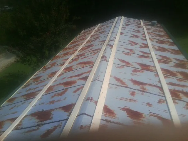 Rusted metal roof panels with new wood purlins before replacement — Storm Damage Roof Repair in Roper by Roofing Brothers