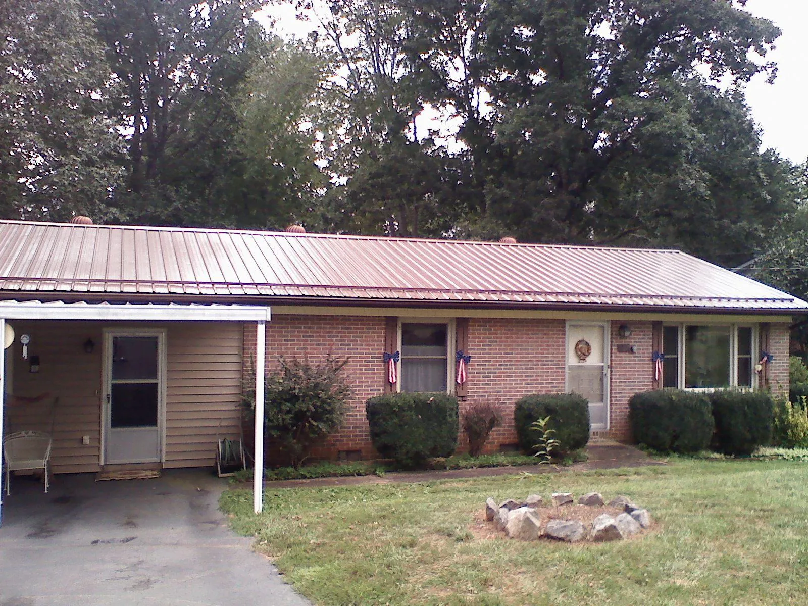 Bronze metal roof and carport on a brick ranch home — Roof Repair work by our crew in Roper